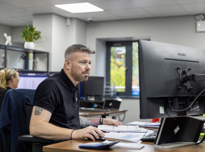 C&C staff member holding a mouse working using a computer