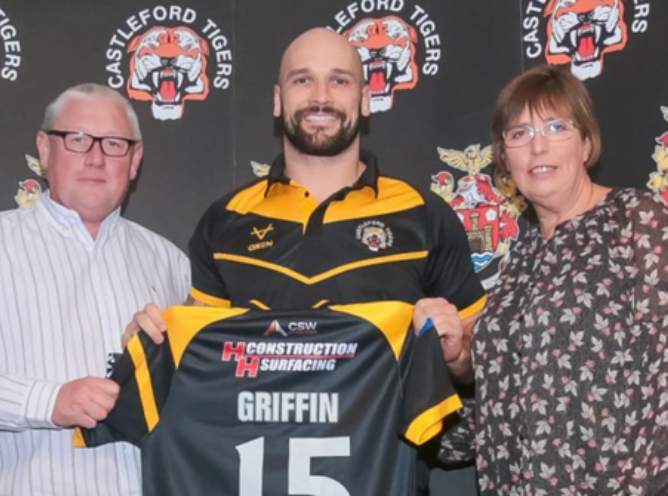 C&C owners and Castleford tiger players holding up Castleford tigers shirt